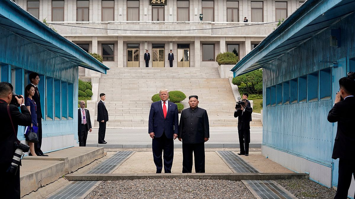 Image: President Donald Trump and North Korean leader Kim Jong Un stand at 