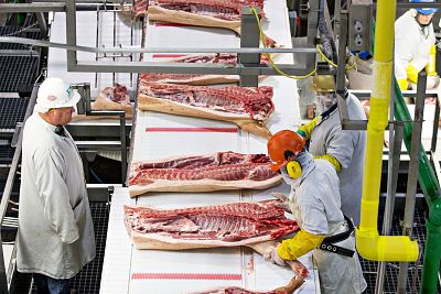 Employees handle sides of pork on a conveyor belt at a Smithfield Foods Inc. pork processing facility in Milan, Missouri, on April 12, 2017. Smithfield foods is one of the five processing plants involved in the pilot program.