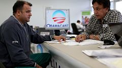 Image: Ariel Fernandez, left, sits with Noel Nogues, an insurance adviser, 