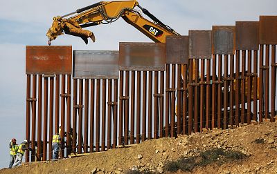 A construction crew installs new sections of the U.S.-Mexico border barrier replacing smaller fences on Jan. 11, 2019 as seen from Tijuana, Mexico.