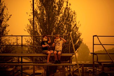Children wear masks to protect them from smoke as they play at an evacuation site in Bega, New South Wales, on Dec. 31.