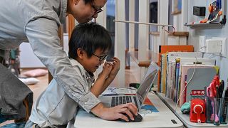 Image: Zhou Ziheng helping his son Vita to create a game with coding on his
