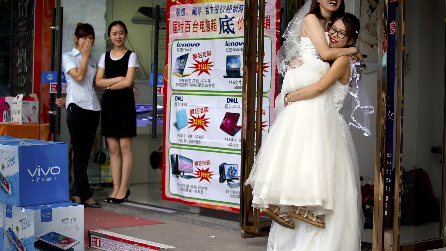 Image: Li Tingting, second from right, laughs as she is lifted off the grou