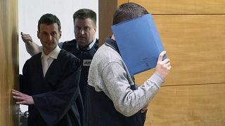 Image: A 57-year old defendant hides his face at the courtroom in Bielefeld