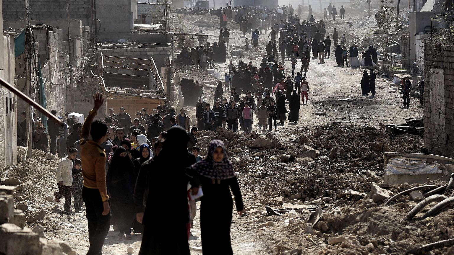 Image: People walk in west Mosul after a food distribution from the Iraqi t