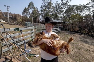 Fern Hutchings, 9, holds her dog in Clifton Creek, Australia, on Thursday. The Hutchings family was evacuated from their home Dec. 30 as wildfires burned around their property.