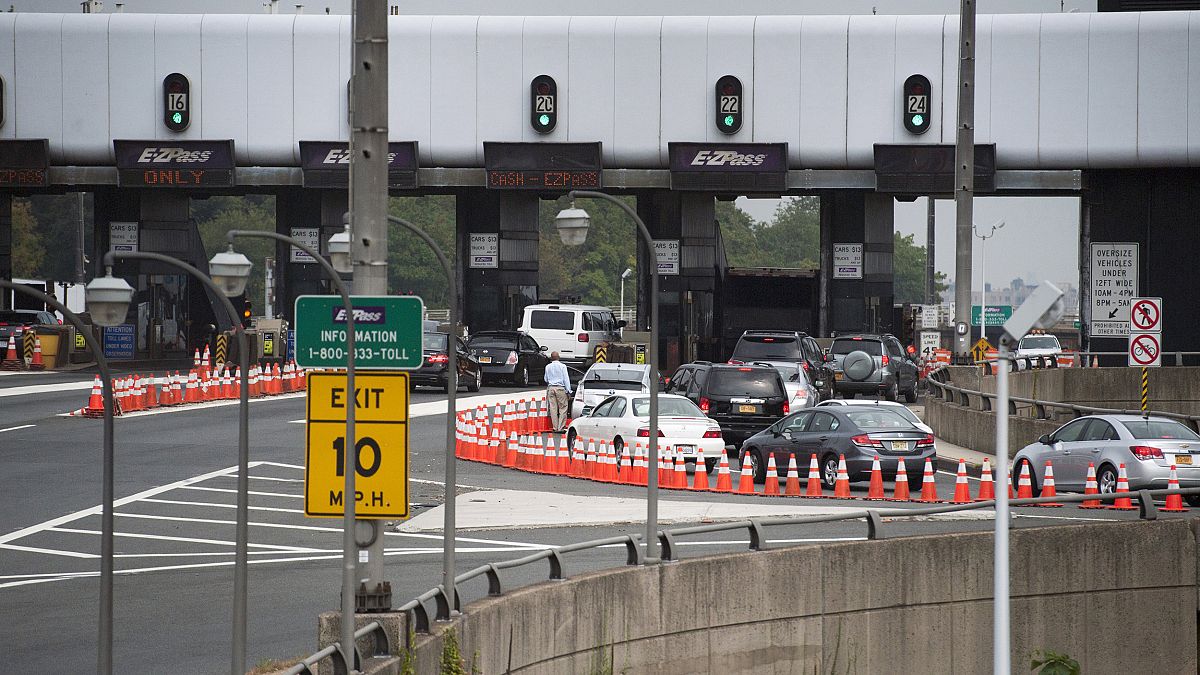 Image: A man gets out of his vehicle to see what the backup is at the toll 