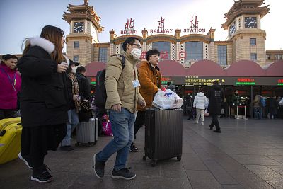 A traveler wears a face mask as he walks outside Beijing Railway Station on Monday.