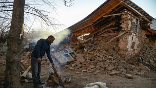 A villager stands by his collapsed house after an earthquake in Sivrice, ne