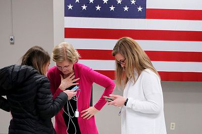 Sen. Elizabeth Warren, D-Mass., is told by an aide that she received the endorsement of the Des Moines Register newspaper in Muscatine, Iowa, on Jan. 25, 2020.