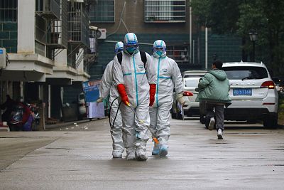 Workers wearing protective clothing disinfect a residential area in Ruichang, in China\'s central Jiangxi province.