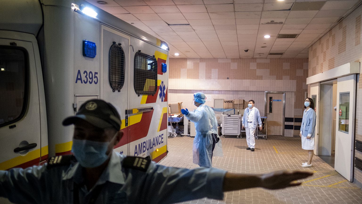 iMAGE: A security official stands guard as an ambulance arrives with a coro