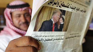 Image: A man holds the daily Asharq Al-Awsat newspaper