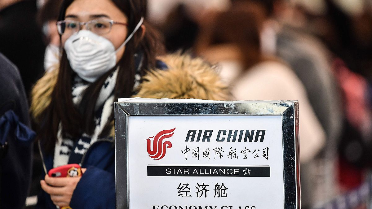 Image: A passenger wearing a respiratory mask waits for check in on Jan. 31