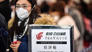 Image: A passenger wearing a respiratory mask waits for check in on Jan. 31