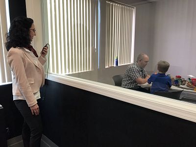 Larissa Niec, a clinical psychologist at Central Michigan University, coaches dad Dru through an in-ear microphone as Dru plays with his son Jericho.