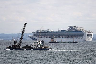 Vessels sail past the Diamond Princess cruise ship with over 3,000 people as it sits anchored in quarantine off the port of Yokohama on Tuesday. 