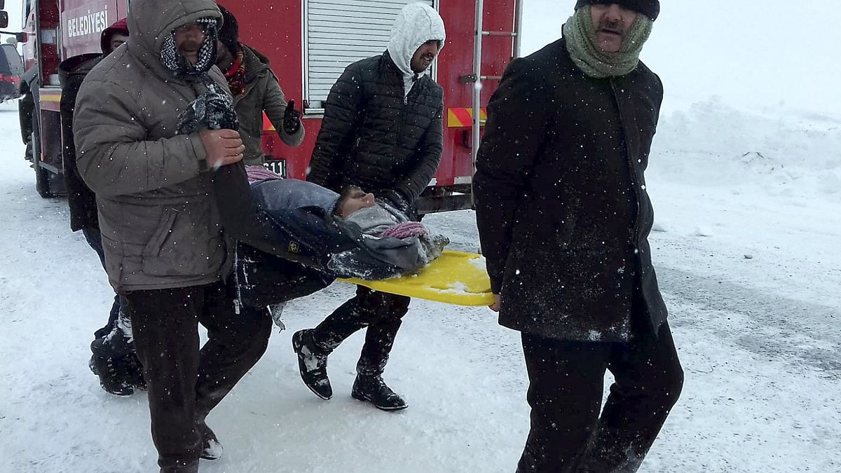 Image: Emergency service members carry a casualty at the site of avalanche 