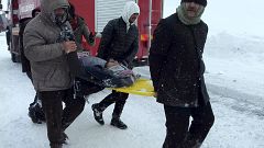 Image: Emergency service members carry a casualty at the site of avalanche 