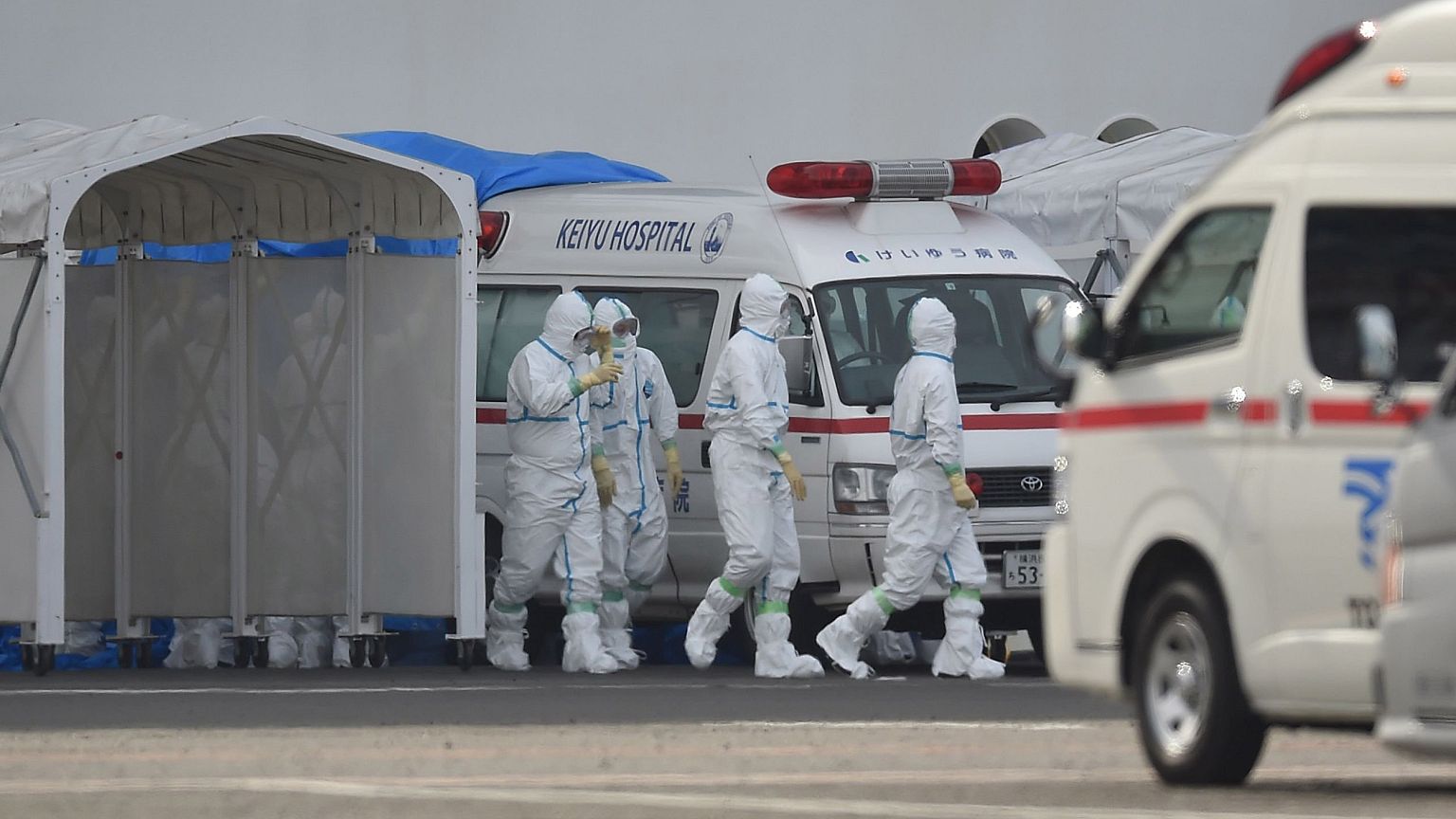 Image: Medical staff wearing protective gear prepare to provide care for su