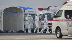 Image: Medical staff wearing protective gear prepare to provide care for su