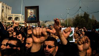 Image: Protesters hold a photo of Iranian General Qassem Soleimani during a