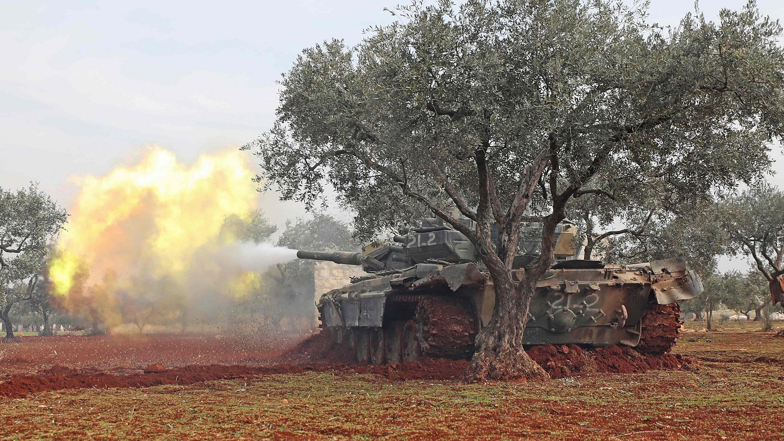Image: Syrian rebel fighters fire from their position in the countryside of