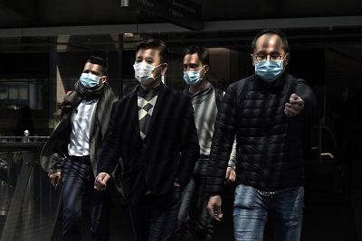 People wearing masks walk in Central, a business district in Hong Kong, on Wednesday. 