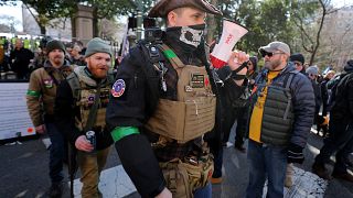 Image: Gun rights advocates wearing body armor and carrying firearms leave 