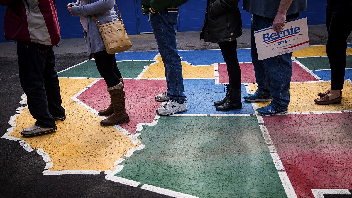 Image: Caucus-goers line up to be counted at Booth Elementary School in Ren