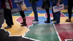 Image: Caucus-goers line up to be counted at Booth Elementary School in Ren