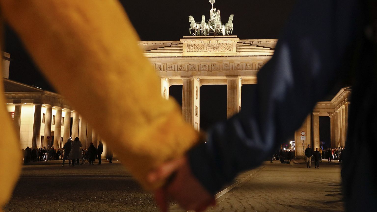 Image: People hold hands as they form a human chain, during a vigil for vic