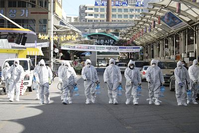 Workers wearing protective gear spray disinfectant as a precaution against the COVID-19 coronavirus at a local market in Daegu, South Korea on Sunday.