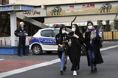 A policeman and pedestrians wear masks to help guard against the Coronavirus, in downtown Tehran, Iran on Sunday. 
