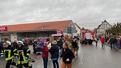 Image: People react at the scene after a car drove into a carnival parade i