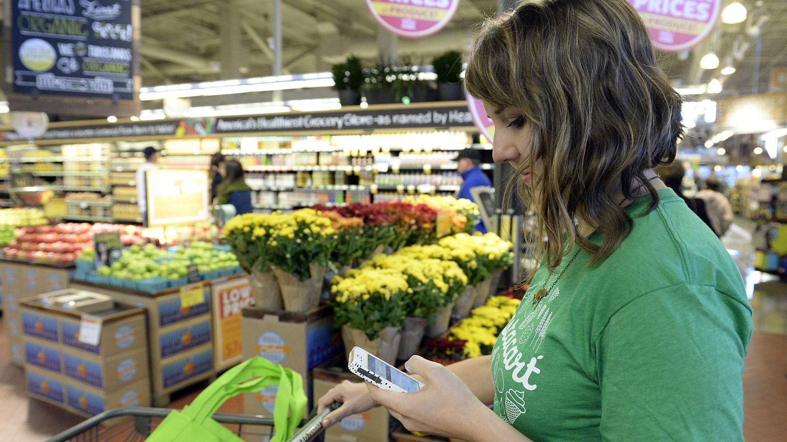 Kaitlin Myers a shopper for Instacart studies her smart phone as she  shops