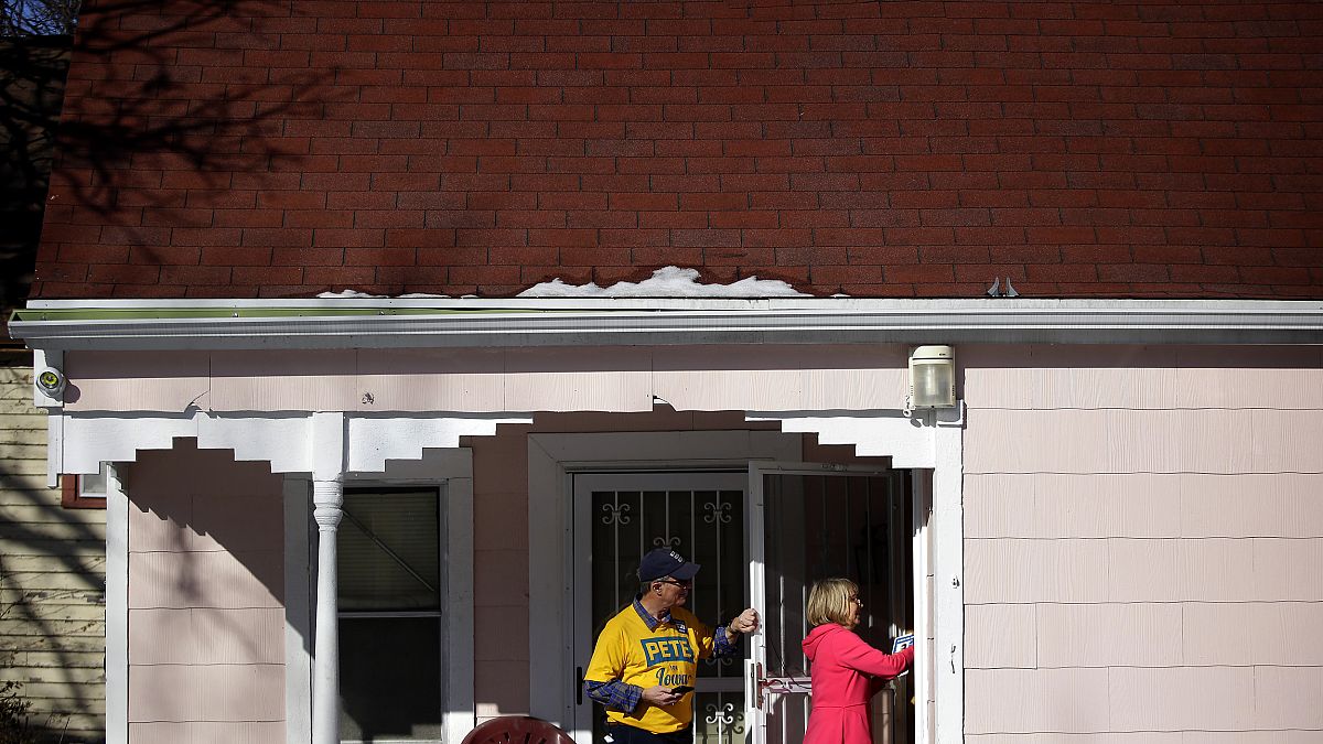 Image: Len Edgerly and Darlene Determan knock on a door while canvasing for