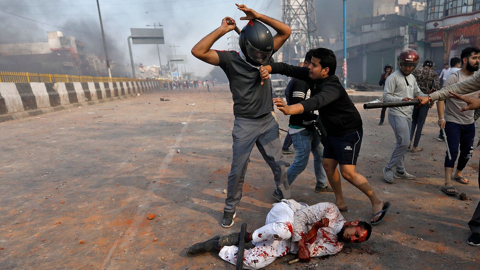Image: A Muslim is beaten by people supporting a new citizenship law beat i