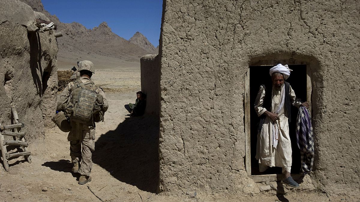 Image: An Afghan man steps out of his house