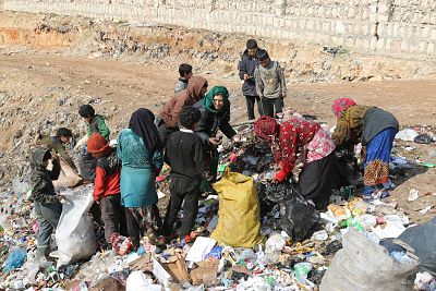 Children pick through a landfill site looking for paper and plastic to burn.