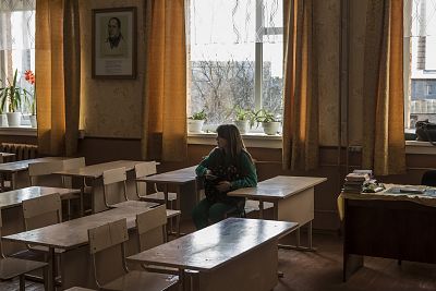 A schoolgirl sits in an empty classroom in Novi Sanzhary, Ukraine.