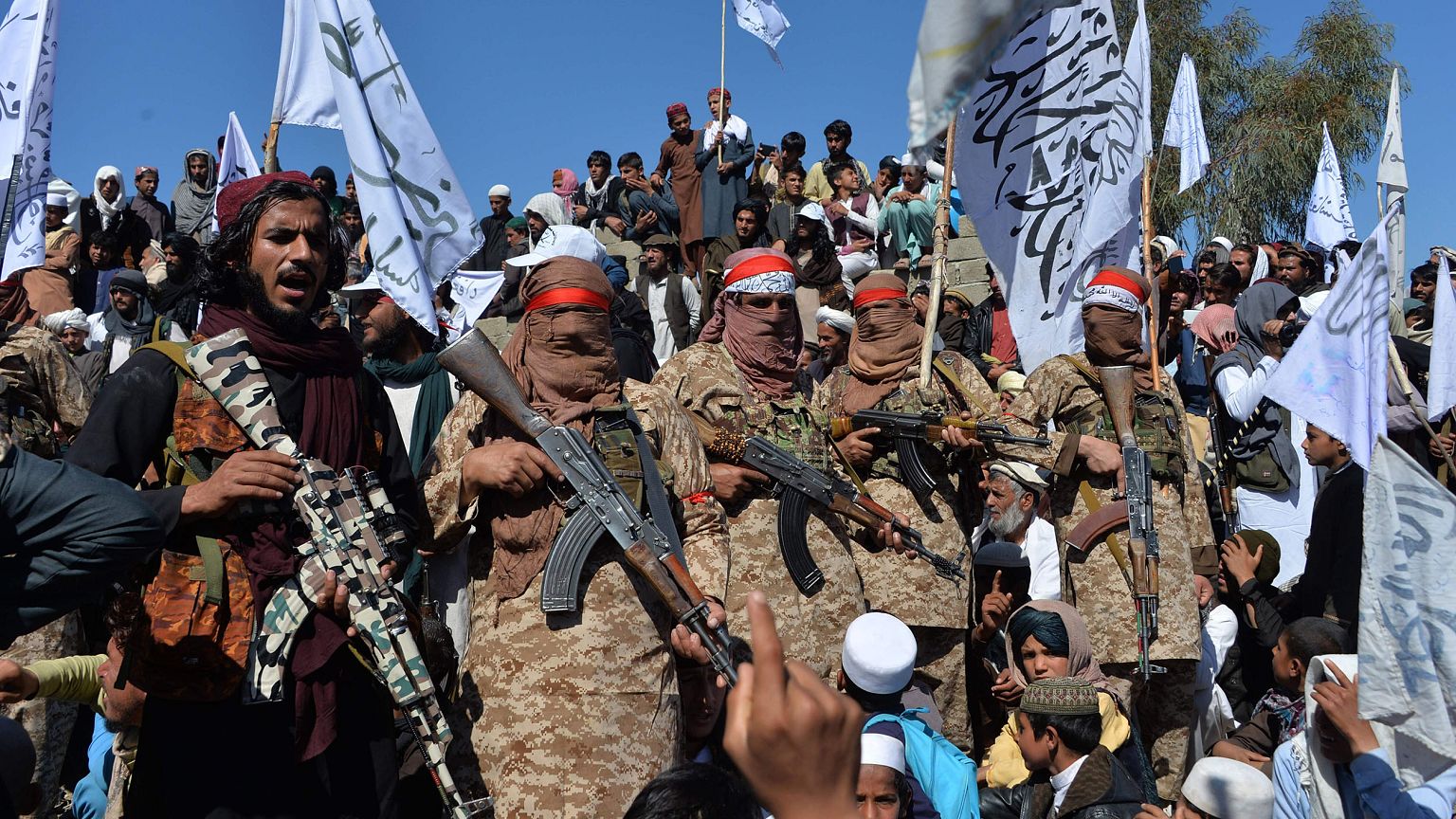 Image: Afghan Taliban militants and villagers attend a gathering as they ce