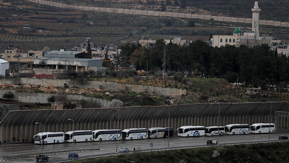 Image: Tourist buses wait at an Israeli checkpoint