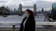 Image: A woman wearing a protective face mask on London Bridge in London