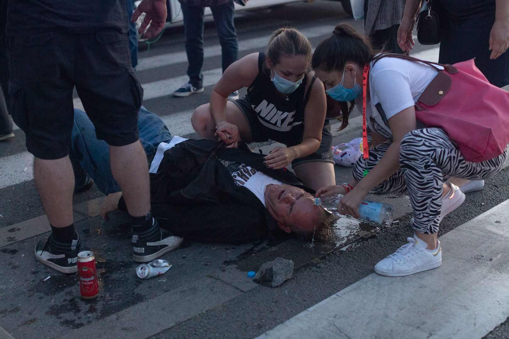 People try to help an injured man during a protest in Belgrade, Serbia. July 8, 2020