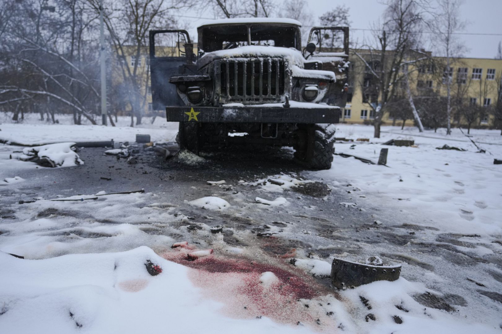 Blood from the body of a serviceman colours the snow next to a destroyed Russian military multiple rocket launcher vehicle on the outskirts of Kharkiv, Ukraine. February 25