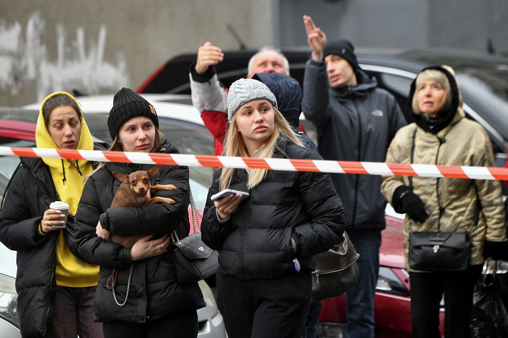 Local residents wait behind the cordon at the site of fallen fragments of Russian rockets, near a multi-storey residential building in Kyiv, Ukraine. March 9, 2023