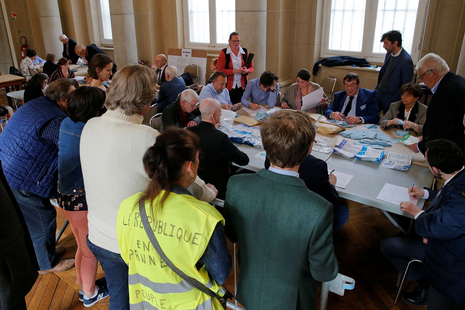 Election officials empty a ballot box as vote counting starts