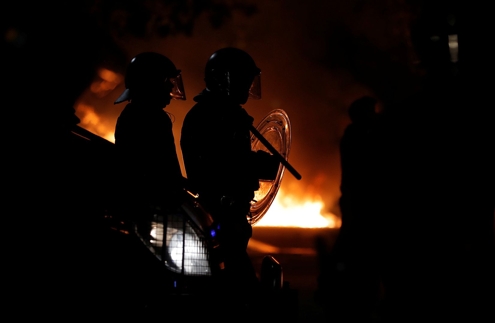 Policía frente a un incendio durante una protesta en Barcelona, España, el 15 de octubre de 2019.