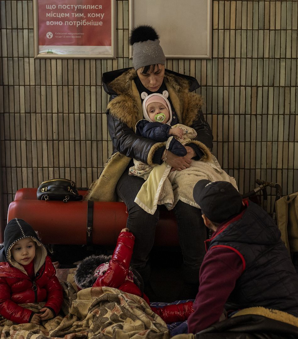 A family sit in the Kyiv subway, using it as a bomb shelter in Kyiv. In Ukraine's capital, many residents hurried underground for safety overnight. February 25, 2022